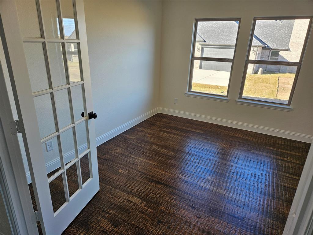 1529 Enloe Road Howe, TX 75459 - Photo 13 of 30 a view of an empty room with wooden floor and a window
