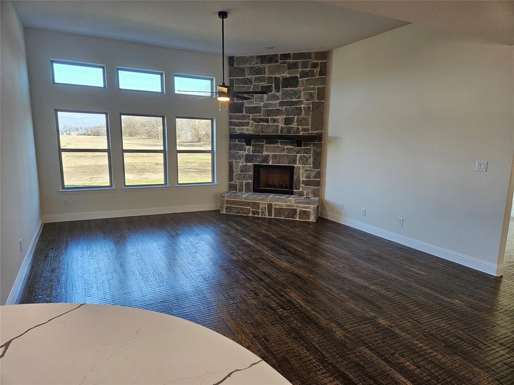 1529 Enloe Road Howe, TX 75459 - Photo 5 of 30 an empty room with wooden floor a fireplace and windows