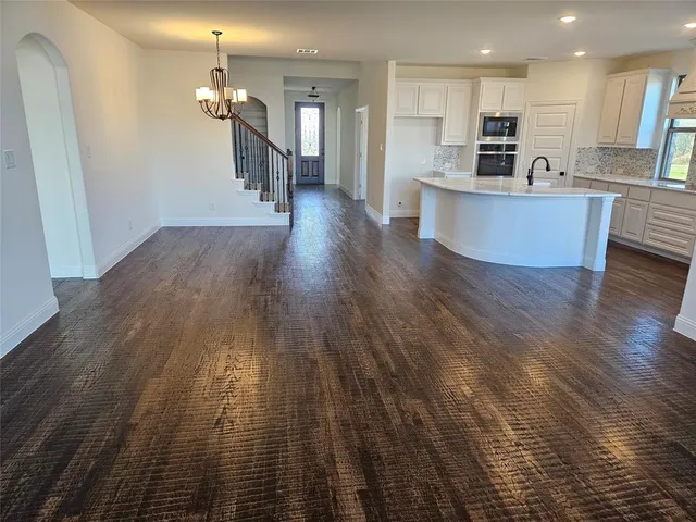a living room with stainless steel appliances kitchen island granite countertop furniture wooden floor and a kitchen view