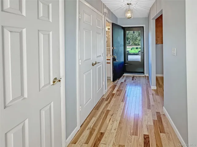 a view of a hallway with wooden floor and furniture