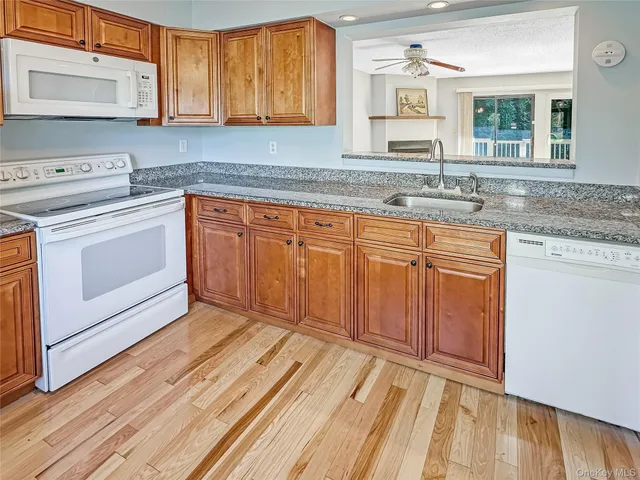 a kitchen with granite countertop cabinets stainless steel appliances and a sink
