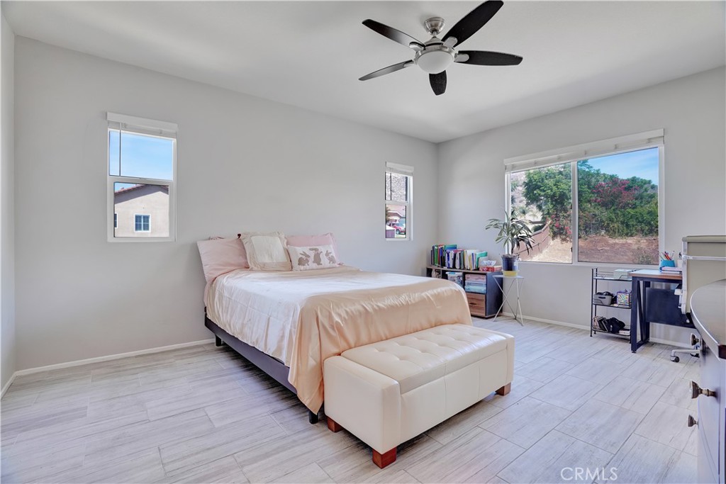 12179 Dewar Drive Riverside, CA 92505 - Photo 15 of 53 a spacious bedroom with a bed a couch and a large window
