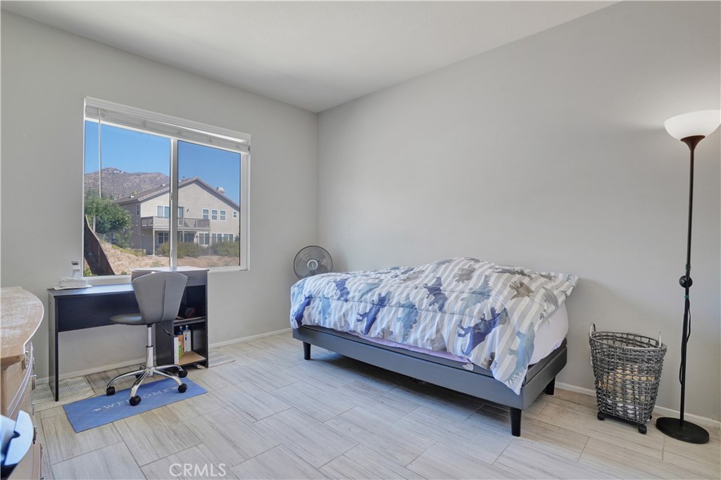 12179 Dewar Drive Riverside, CA 92505 - Photo 22 of 53 a bedroom with a bed windows table and chair