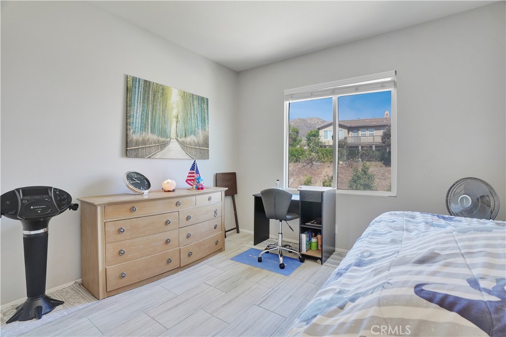 12179 Dewar Drive Riverside, CA 92505 - Photo 23 of 53 a bedroom with a bed and a table in it with window