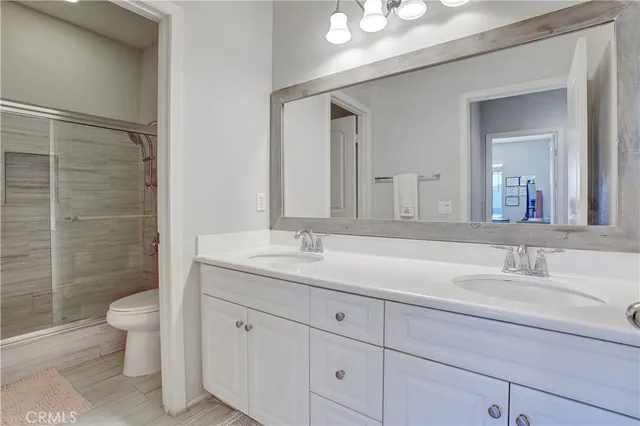 a bathroom with a granite countertop sink a toilet and a mirror