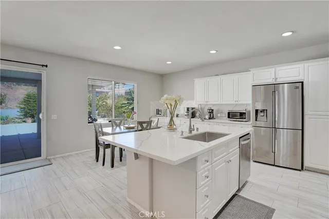 a kitchen with a sink a stove a refrigerator and dining table