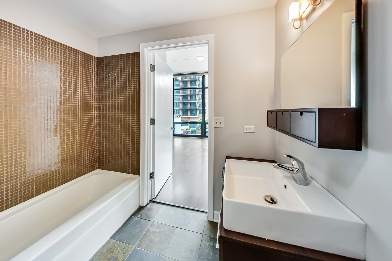 650 West Wayman Street, Unit 503C Chicago, IL 60661 - Photo 9 of 23 a bathroom with a tub sink and mirror