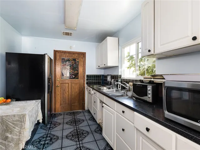 a kitchen with stainless steel appliances granite countertop a refrigerator and a stove