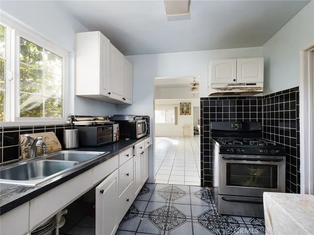 a kitchen with granite countertop a stove sink and cabinets