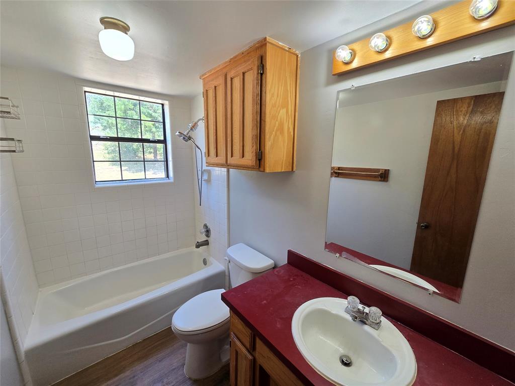 3505 Farmer Road Azle, TX 76020 - Photo 17 of 40 Downstairs full bathroom services two bedrooms and guests. Tile shower surround and toiletry and linen cabinets built-in.