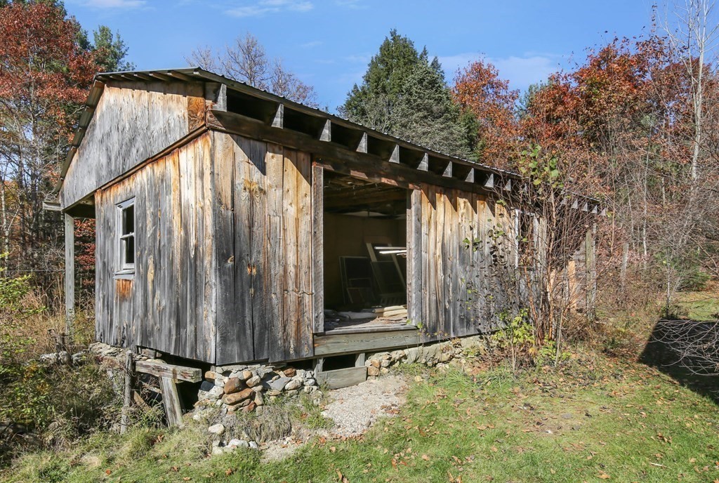 27 Locke Road Rutland, MA 01543 - Photo 32 of 39 a view of wooden house with a large windows and flower plants