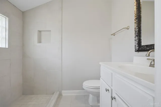 a bathroom with a sink toilet vanity and window