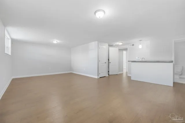 a view of an empty room with a kitchen