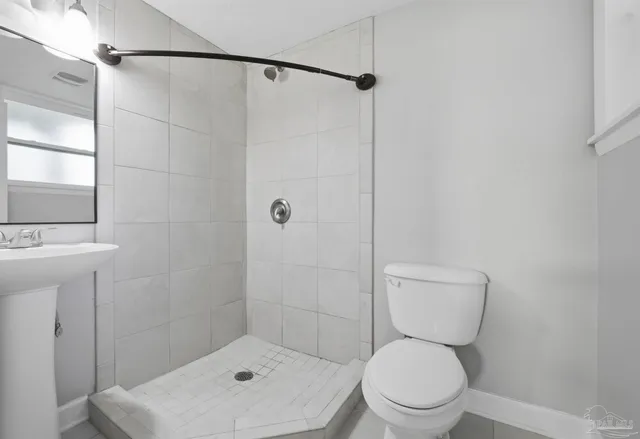 a white toilet sitting next to a bathroom sink