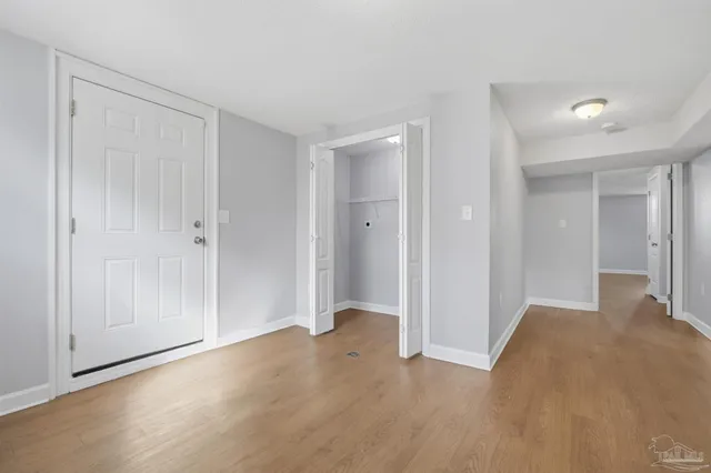 a view of empty room with wooden floor