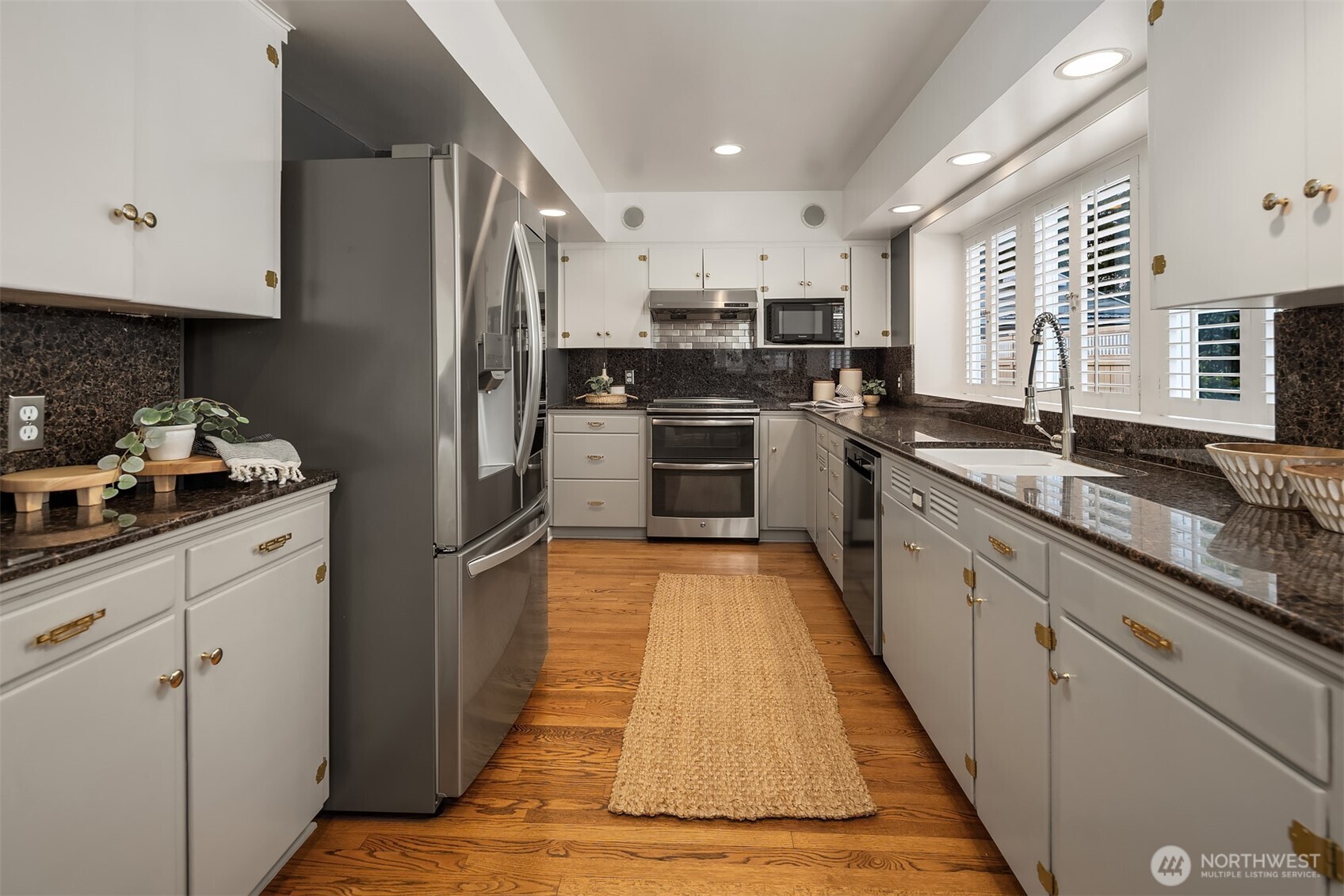 640 Alverson Boulevard Everett, WA 98201 - Photo 18 of 40 a large kitchen with stainless steel appliances granite countertop a refrigerator a sink dishwasher a stove and white countertops with wooden floor