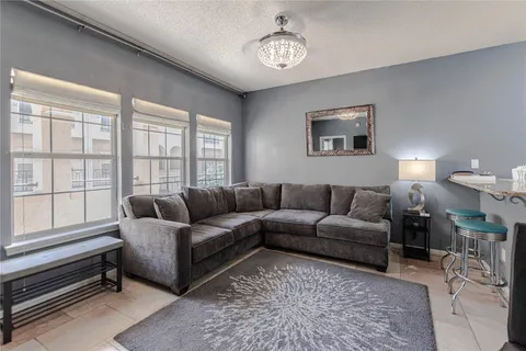 a living room with furniture a chandelier and a window