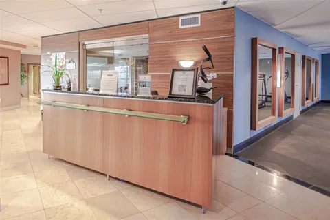 a view of a large room with wooden floor and windows