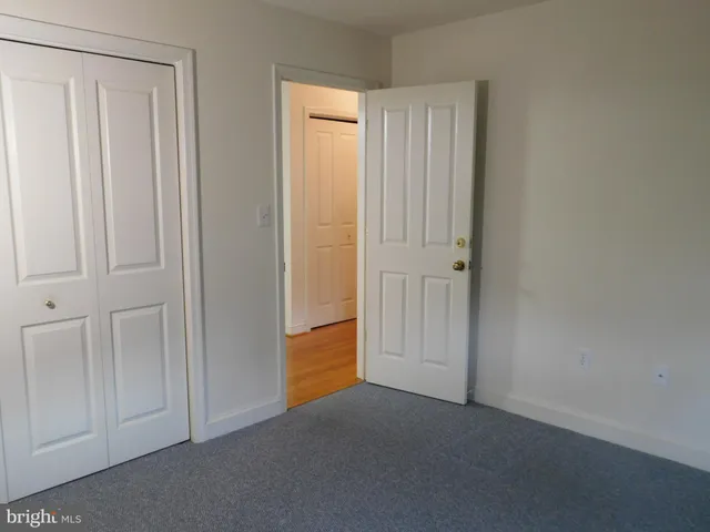 an empty room with windows and closet