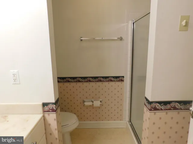 a bathroom with a granite countertop shower and a toilet
