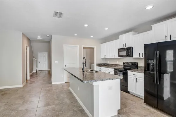 a kitchen with stainless steel appliances granite countertop a refrigerator and a stove top oven