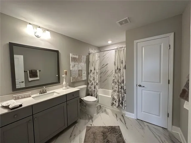 a bathroom with a double vanity sink toilet and mirror