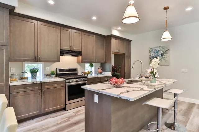 a kitchen with kitchen island stainless steel appliances a dining table and chairs