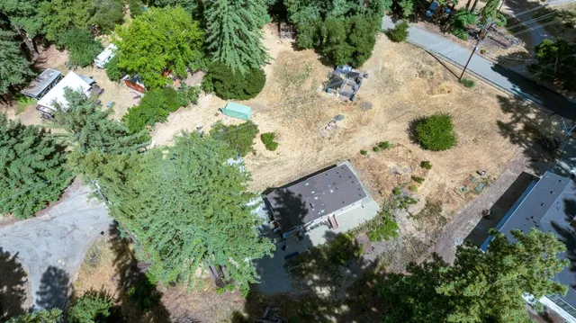 an aerial view of a house with a yard and green space