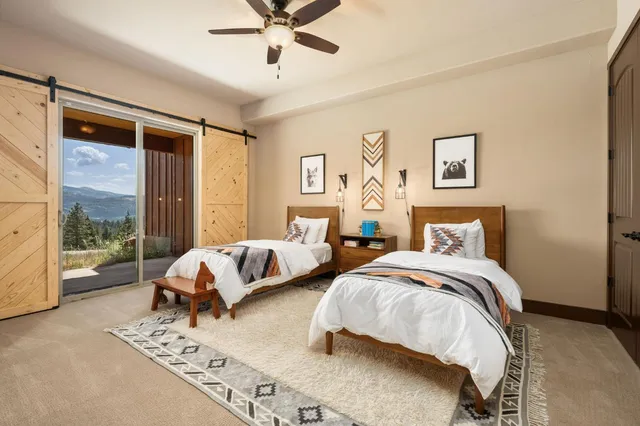 a spacious bedroom with two beds and glass window