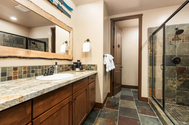 a bathroom with a granite countertop sink and a mirror