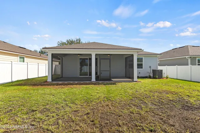 a view of a house with a patio and a yard