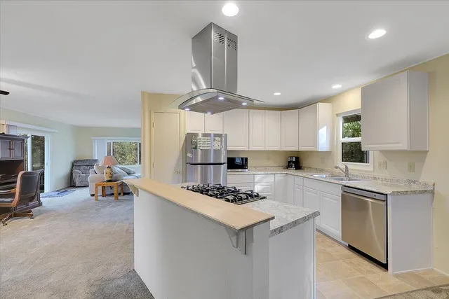 a kitchen with a sink a stove and chairs