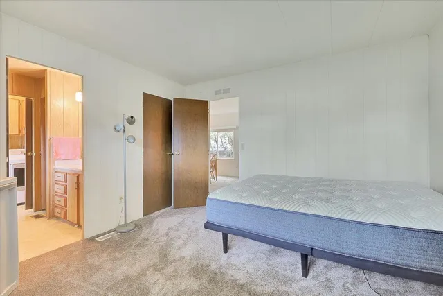 a living room with a table and a refrigerator