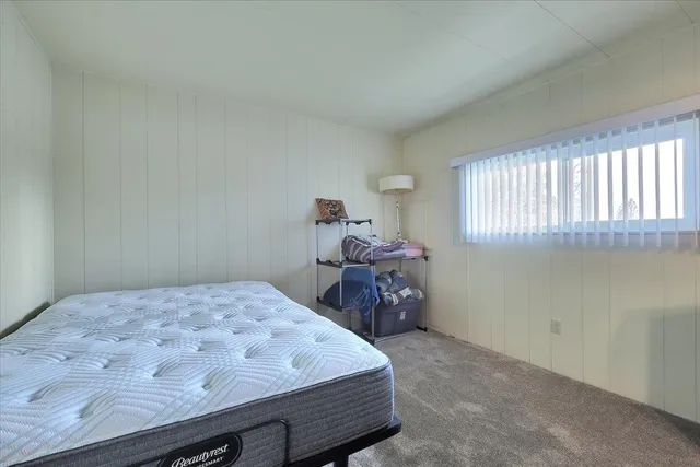 a bed sitting in a bedroom next to a window