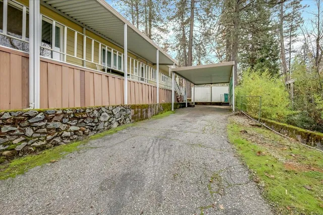a view of a house with a small yard and a large tree