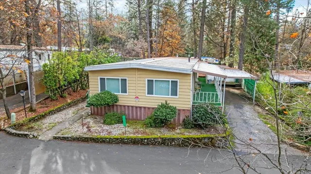 a view of a house with a yard and large tree