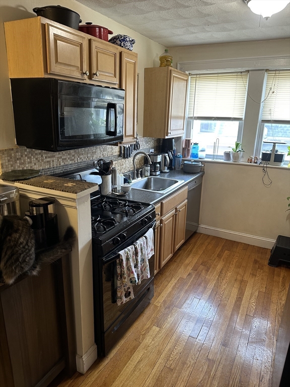 38 Day Street, Unit 20 Somerville, MA 02144 - Photo 6 of 9 a kitchen with stainless steel appliances a stove a microwave a sink and cabinets