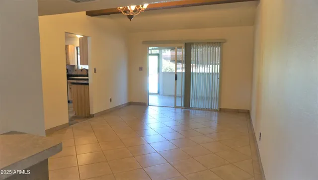 a view of a hallway with wooden floor and a bathroom