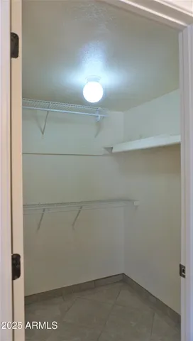 a view of an empty room with wooden floor and closet