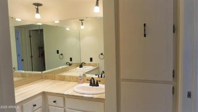 a spacious bathroom with a double vanity sink a mirror and a shower