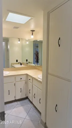 a bathroom with a double vanity sink a toilet and a mirror