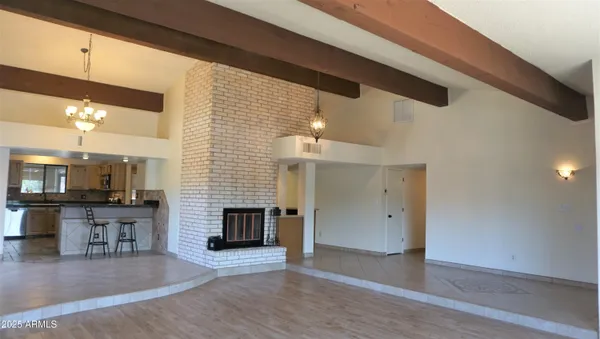 a view of a livingroom with kitchen and fireplace