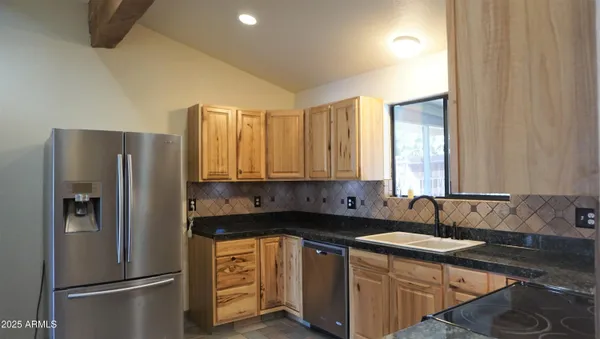 a kitchen with stainless steel appliances granite countertop a refrigerator and a sink