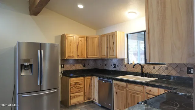 a kitchen with stainless steel appliances granite countertop a refrigerator and a sink