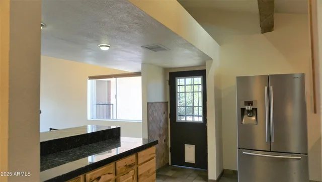 a kitchen with stainless steel appliances a refrigerator and a window