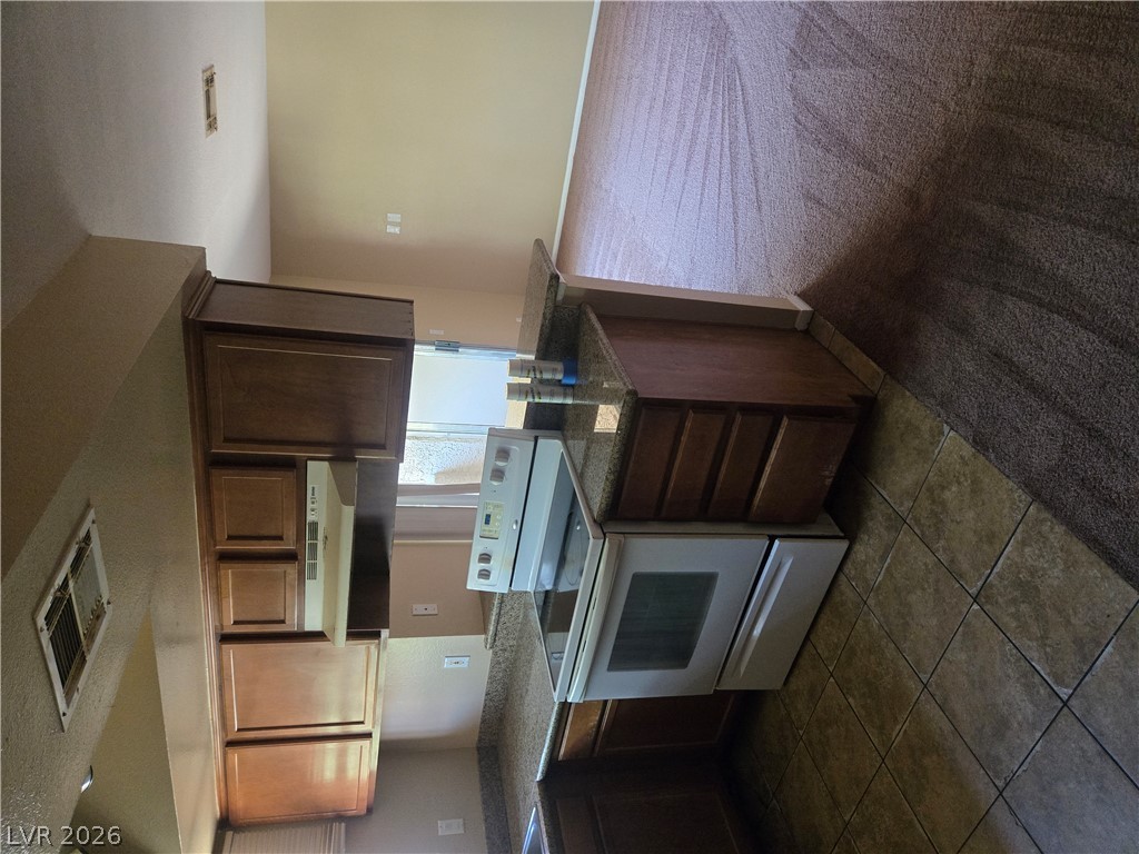7200 West Pirates Cove Road, Unit 2047 Las Vegas, NV 89145 - Photo 2 of 17 Functional kitchen with ample cabinetry and a convenient pass-through counter to the adjacent living space.