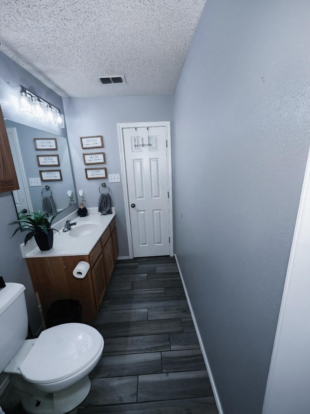 6821 84th Street Lubbock, TX 79424 - Photo 12 of 14 a bathroom with sink toilet mirror and vanity