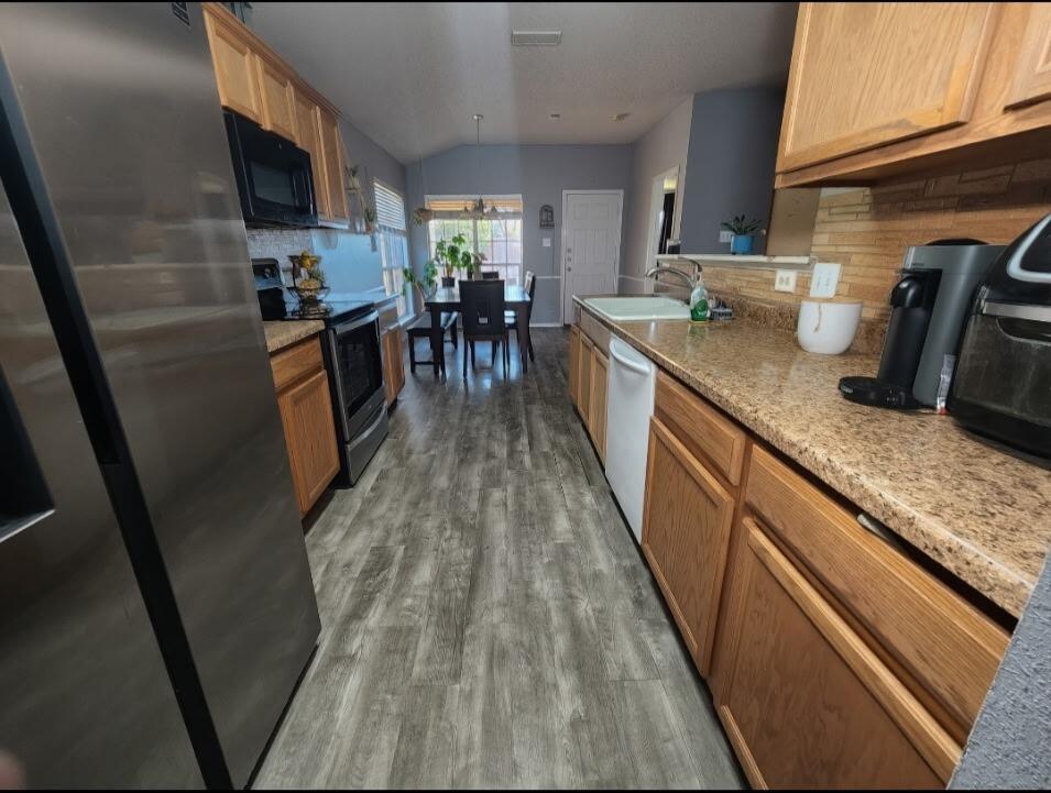 6821 84th Street Lubbock, TX 79424 - Photo 4 of 14 a kitchen with granite countertop lots of counter top space and wooden floor