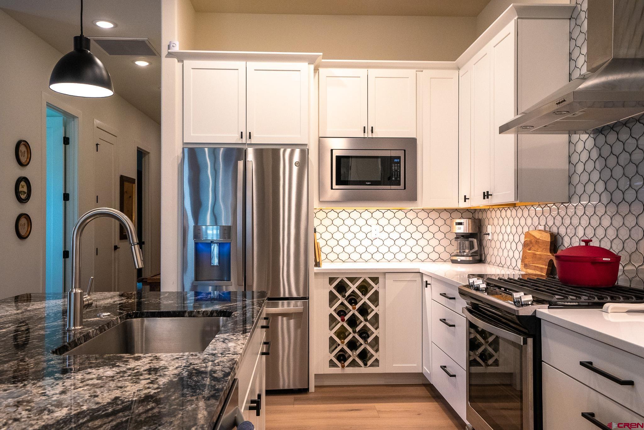 236 Via Tuscana Durango, CO 81301 - Photo 12 of 31 a kitchen with stainless steel appliances granite countertop a stove a sink and a refrigerator
