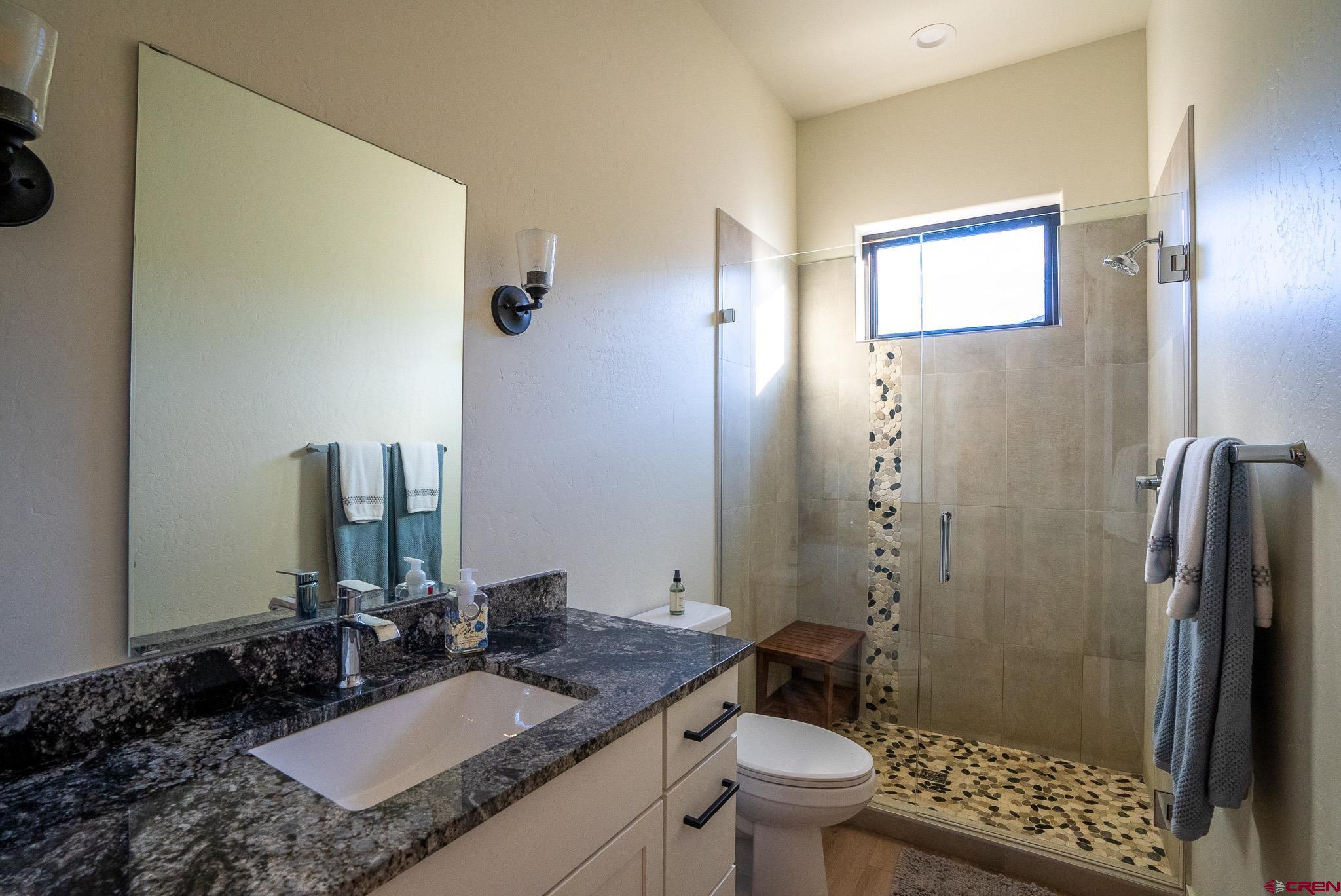 236 Via Tuscana Durango, CO 81301 - Photo 23 of 31 a bathroom with a granite countertop sink toilet and shower